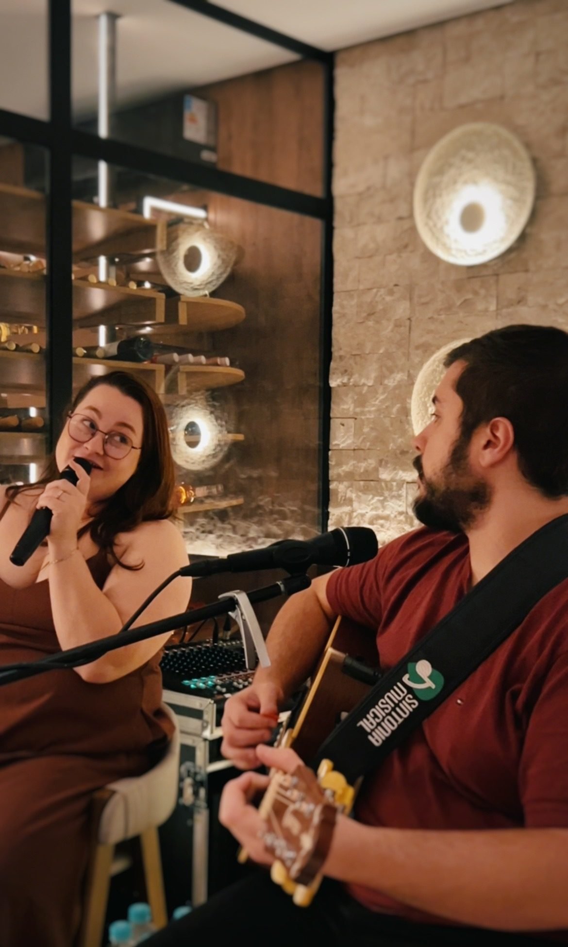 Jaque cantando e Thiago tocando violão em uma apresentação da Sonare